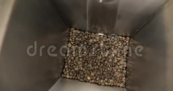 在工厂车间冷却装置平台上旋转混合的烘焙咖啡豆视频的预览图