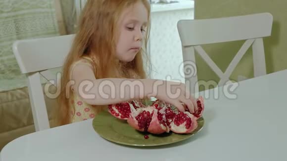 金发快乐的小女孩吃石榴健康的食物理念特写肖像视频的预览图