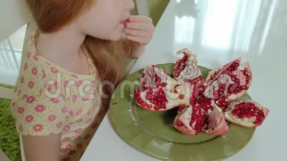 金发快乐的小女孩吃石榴健康的食物理念特写肖像视频的预览图