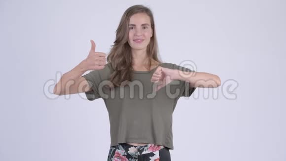 年轻迷茫的美丽女子在竖起大拇指和向下大拇指之间做出选择视频的预览图