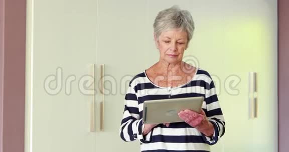 年长的女人用她的平板电脑视频的预览图
