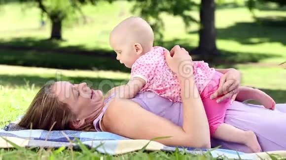 快乐的妈妈在公园里和她的宝贝女儿玩视频的预览图