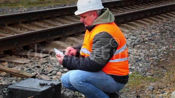 铁路附近有平板电脑电话的工人视频的预览图