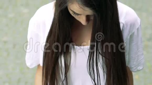 一幅美丽的黑发在镜头前微笑的肖像慢慢地视频的预览图