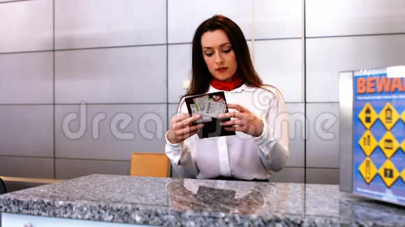 女机场工作人员在登记台检查护照视频的预览图
