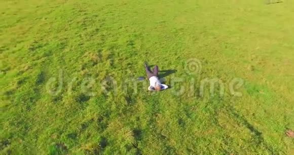 低轨道飞行围绕着绿草上的人与笔记本垫在黄色的农村田野视频的预览图