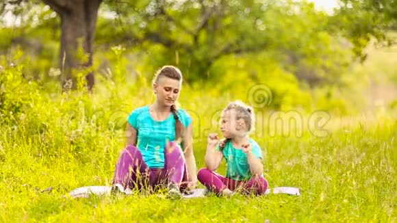 母亲和女儿坐在大自然上视频的预览图
