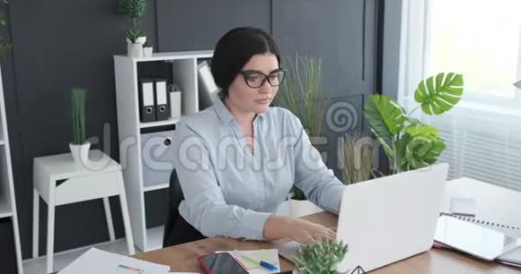 女商人在办公室用笔记本电脑视频的预览图