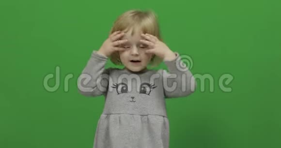 小女孩在绿色屏幕上键快乐的三岁女孩视频的预览图