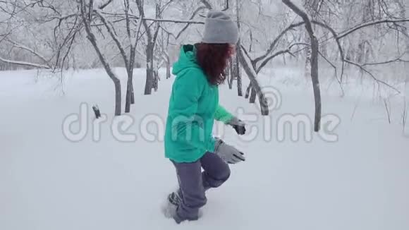 一个女孩正走在一个白雪覆盖的公园里视频的预览图
