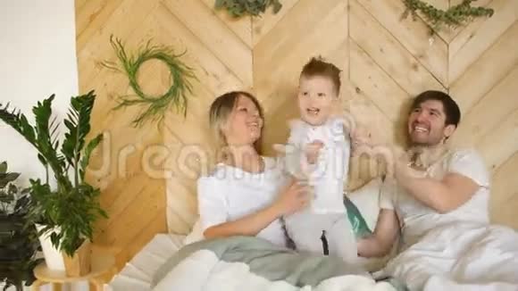 一个小儿子的年轻家庭在卧室里睡觉视频的预览图