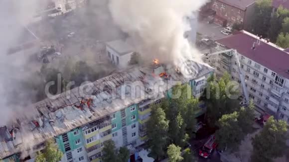 燃烧屋顶的一栋住宅高层建筑云烟自火消防队员灭火顶部视频的预览图