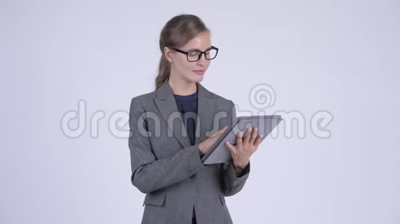 年轻快乐的女商人用数码平板电脑思考视频的预览图