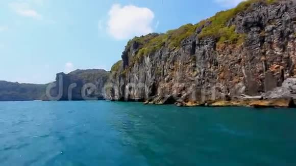 在岩石岛旁边航行快艇视频的预览图