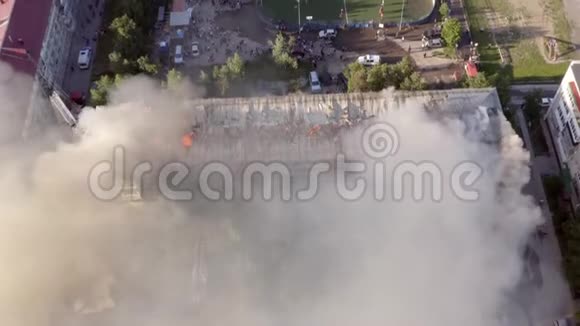 燃烧屋顶的一栋住宅高层建筑云烟自火消防队员灭火顶部视频的预览图