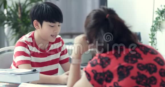 严肃的亚洲妈妈和儿子在客厅做作业视频的预览图
