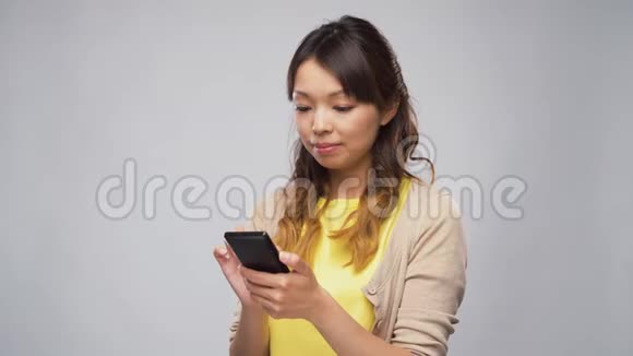 亚洲女人在打智能手机视频的预览图