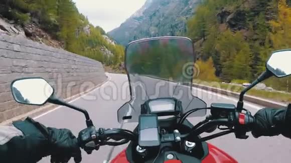 骑摩托车的摩托车骑在瑞士阿尔卑斯山附近美丽的风景山路上视频的预览图