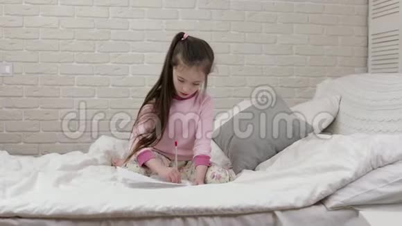 可爱的小女孩躺在床上画画视频的预览图