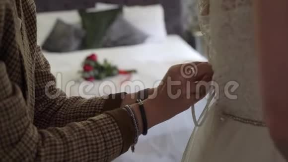 伴娘帮助年轻新娘穿上婚纱豪华婚纱视频的预览图