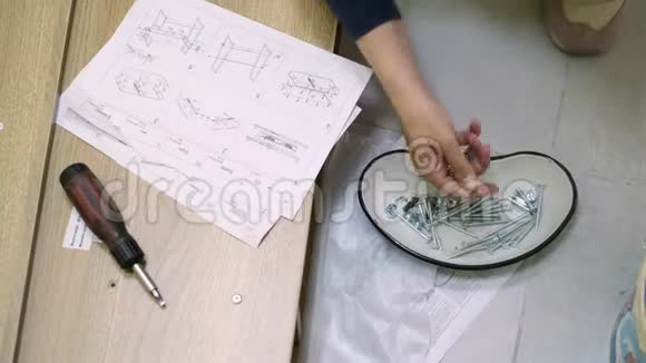白人中年妇女组装家具视频的预览图