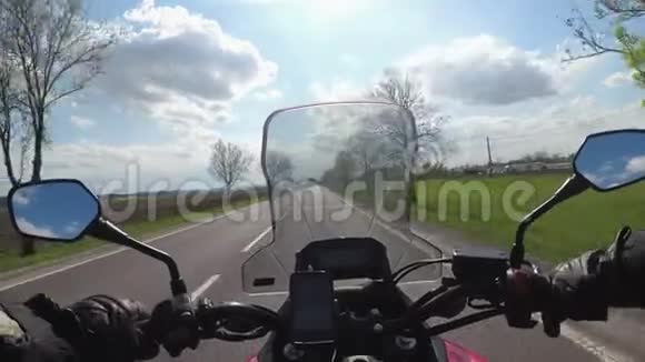 骑在高速公路上的摩托车手从摩托车车轮后面看POV视频的预览图