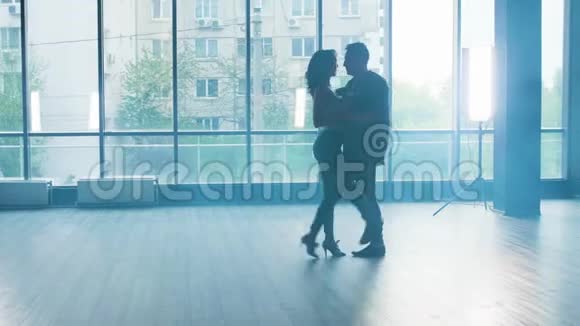 一对年轻的夫妇在一个烟雾弥漫的工作室里激情地跳舞视频的预览图