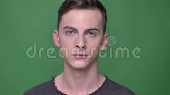 年轻英俊的白种人男性面部特写镜头直视镜头背景与绿色隔离视频的预览图