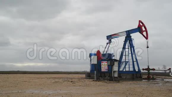 在油田开采天然气时使用的抽水机从油井中抽水视频的预览图