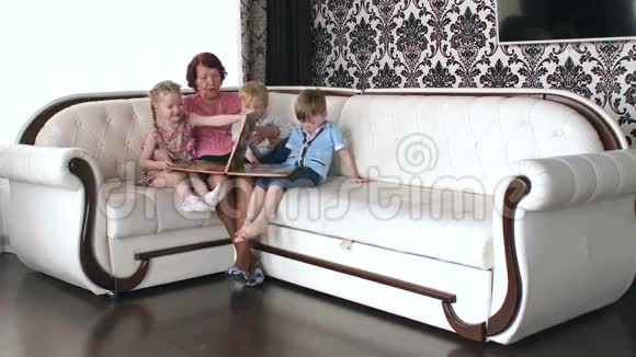 祖母带着孙子坐在沙发上视频的预览图