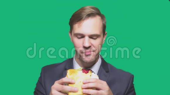 商人在绿色背景下吃三明治快速午餐概念视频的预览图