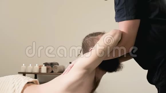 一位男性理疗师在医疗按摩室为一位男性位男性患者做伸展运动使其伸展到一位留着胡须的年轻臀部视频的预览图
