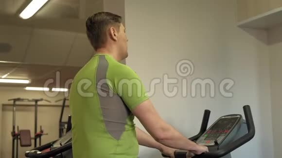 在健身房骑运动自行车的人健康生活方式视频的预览图