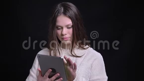 年轻迷人的白种人女性的特写肖像使用平板电脑微笑并显示绿色彩色屏幕相机视频的预览图