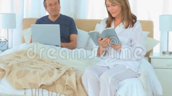 有笔记本电脑和书的成熟夫妻视频的预览图