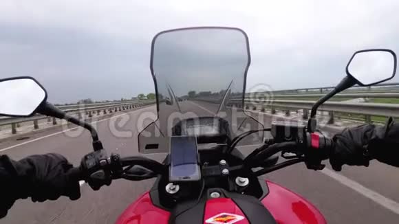 骑在高速公路上的摩托车手从摩托车车轮后面看POV视频的预览图