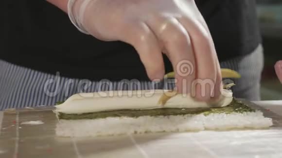专业寿司厨师在商业厨房准备卷特写视频的预览图