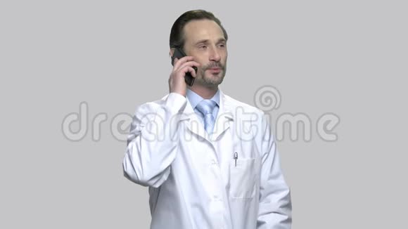 微笑着成熟的医生在电话里交谈视频的预览图