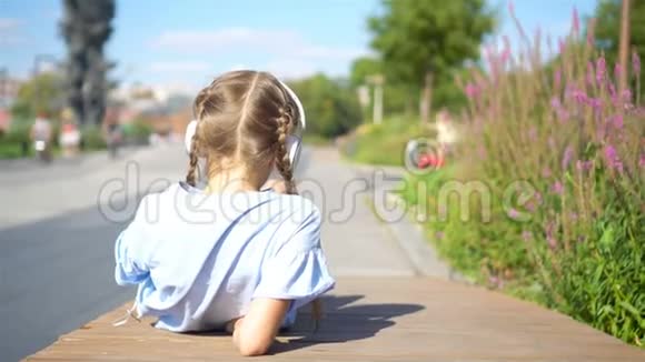 小可爱的女孩在公园里听音乐视频的预览图