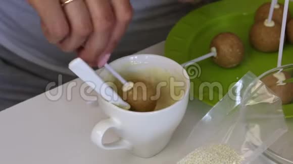 一个女人正在用白巧克力蘸一块纸饼桌子上的下一个是做流行蛋糕的原料视频的预览图