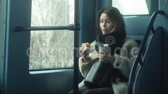 年轻的黑发女人乘坐公共交通工具带着耳机使用电话视频的预览图