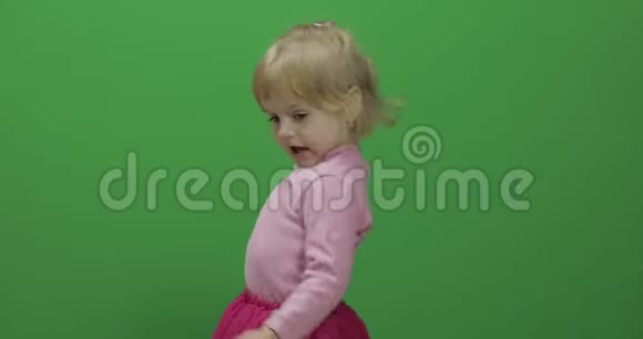 快乐的三岁女孩可爱的金发孩子跳舞和做脸视频的预览图