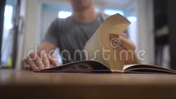 人在看一本书慢动作视频教育学习图书馆的概念生活方式男人打开了这本书男人转身视频的预览图