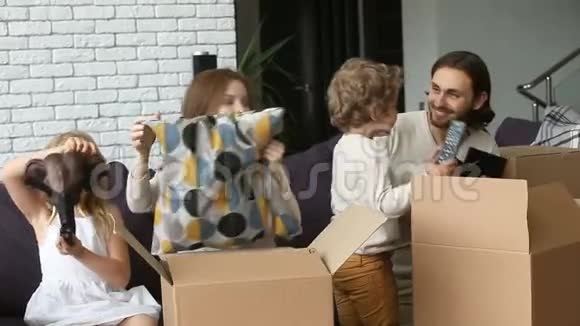 带孩子的幸福家庭在客厅沙发上打开箱子视频的预览图