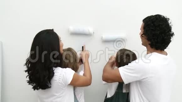 一家人用画笔在家中画一堵墙视频的预览图