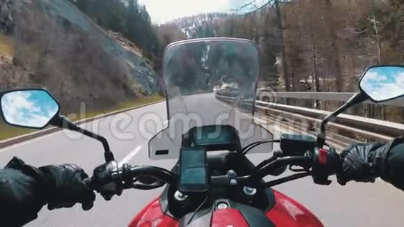 摩托车手骑在瑞士阿尔卑斯山附近美丽的风景山路上视频的预览图