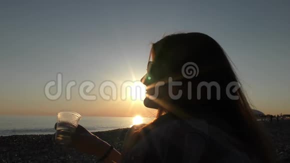 日落时分海滩上年轻迷人的女人视频的预览图