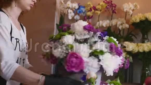 花店花店布置现代花束年轻英俊的花店在花店做花束视频的预览图