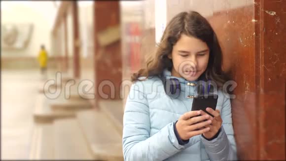 少女在地下地铁中乘坐生活方式地铁等待火车的到来手持智能手机视频的预览图