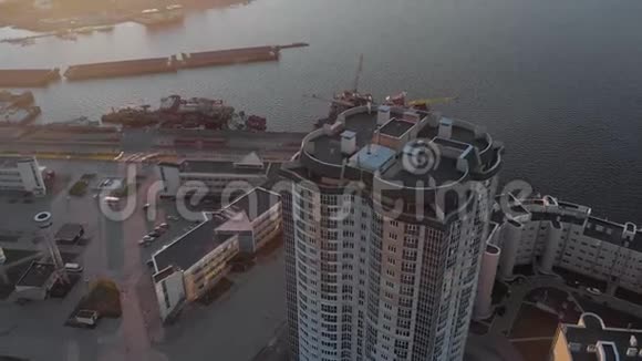 城市景观河岸上的住宅综合体日落时直升机的空中镜头视频的预览图